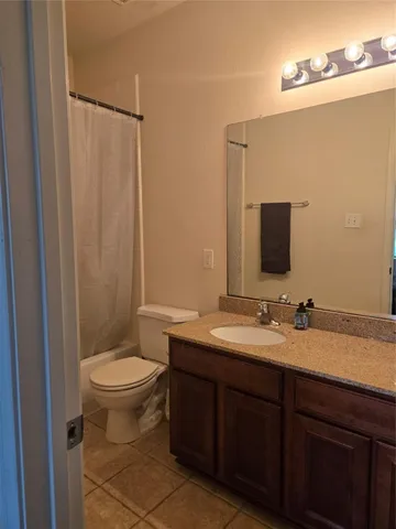 a bathroom with a granite countertop sink toilet and mirror