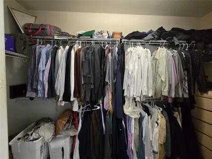 a view of walk in closet with clothes and shoes