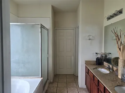 a bathroom with a granite countertop sink a mirror and a bathtub
