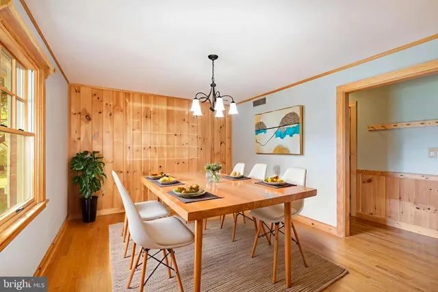 a dining room with furniture a chandelier and wooden floor
