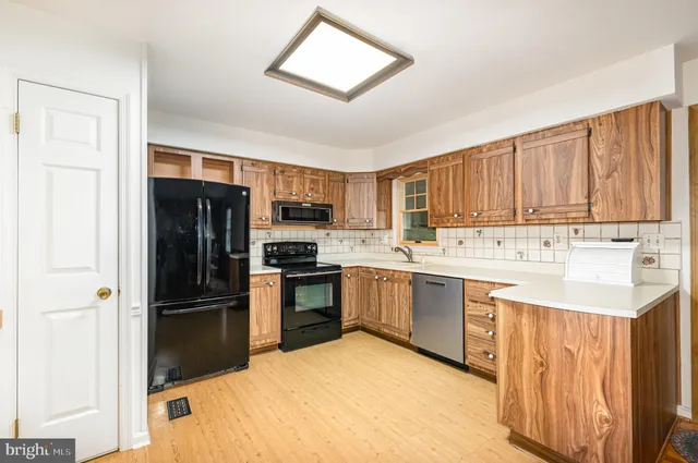 a kitchen with stainless steel appliances granite countertop a refrigerator sink and stove