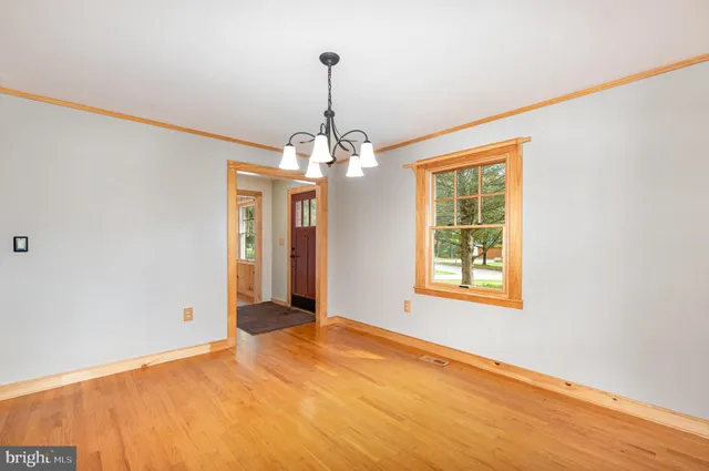 a view of a livingroom with a chandelier fan and window