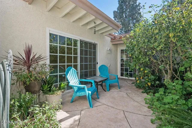 a view of a chair and table in the back yard of the house