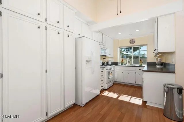 a kitchen with white cabinets and white appliances
