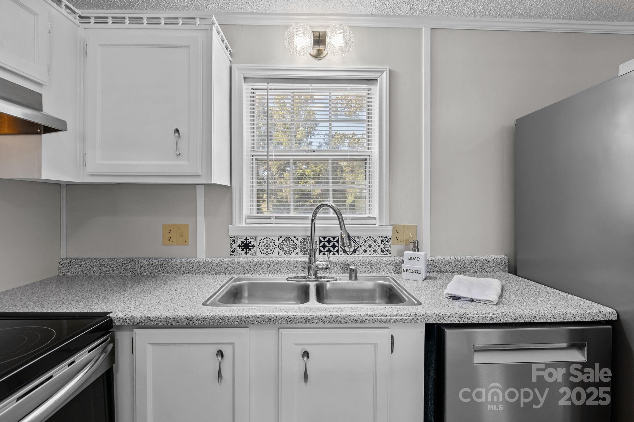 555 Fairmount Road Statesville, NC 28625 - Photo 18 of 48 a kitchen with stainless steel appliances granite countertop a sink and a white cabinets