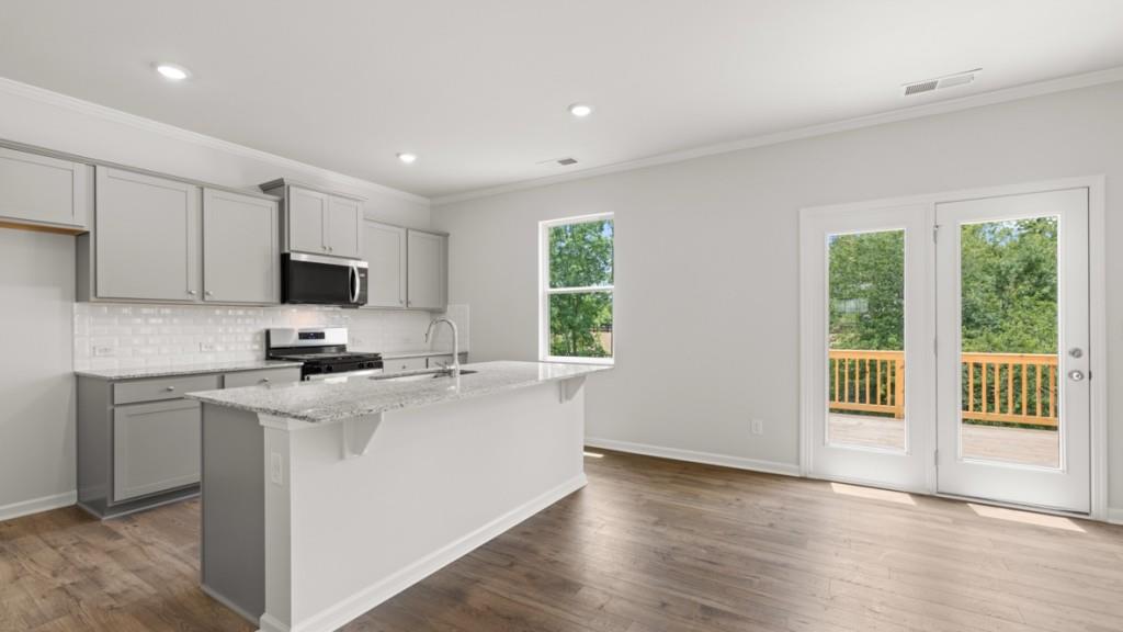 174 Thompson Ridge Lane Dallas, GA 30132 - Photo 6 of 35 a kitchen with stainless steel appliances a microwave a sink a stove a refrigerator cabinets and a window