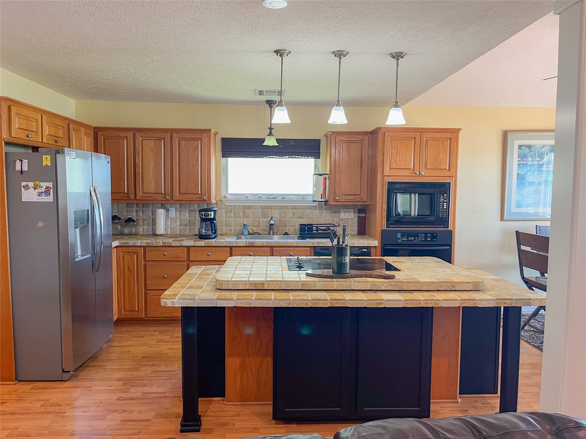 231 Memphis Belle Trinity, TX 75862 - Photo 27 of 47 a kitchen with kitchen island granite countertop a sink refrigerator and cabinets
