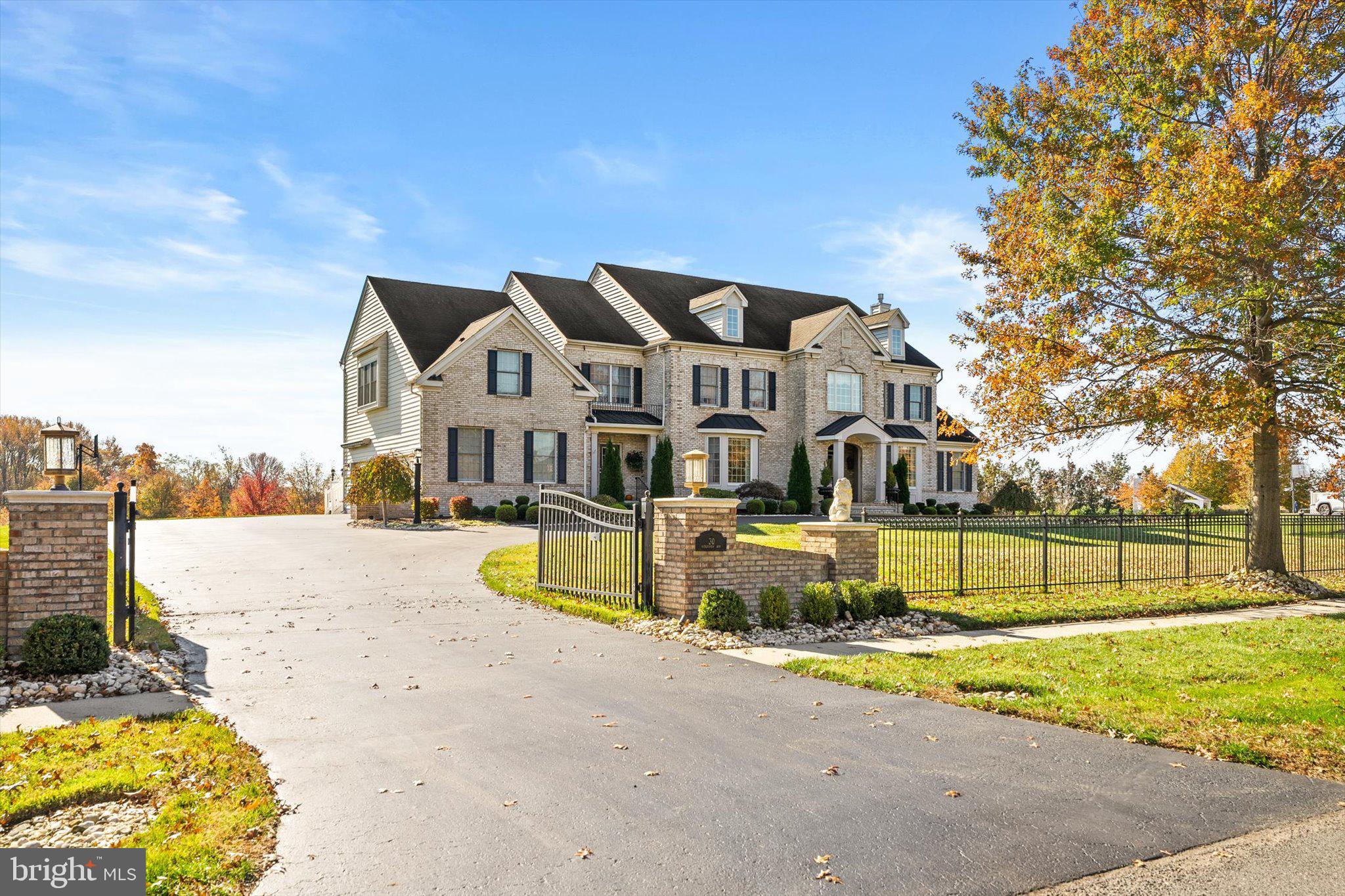 a view of a house with a big yard and large trees