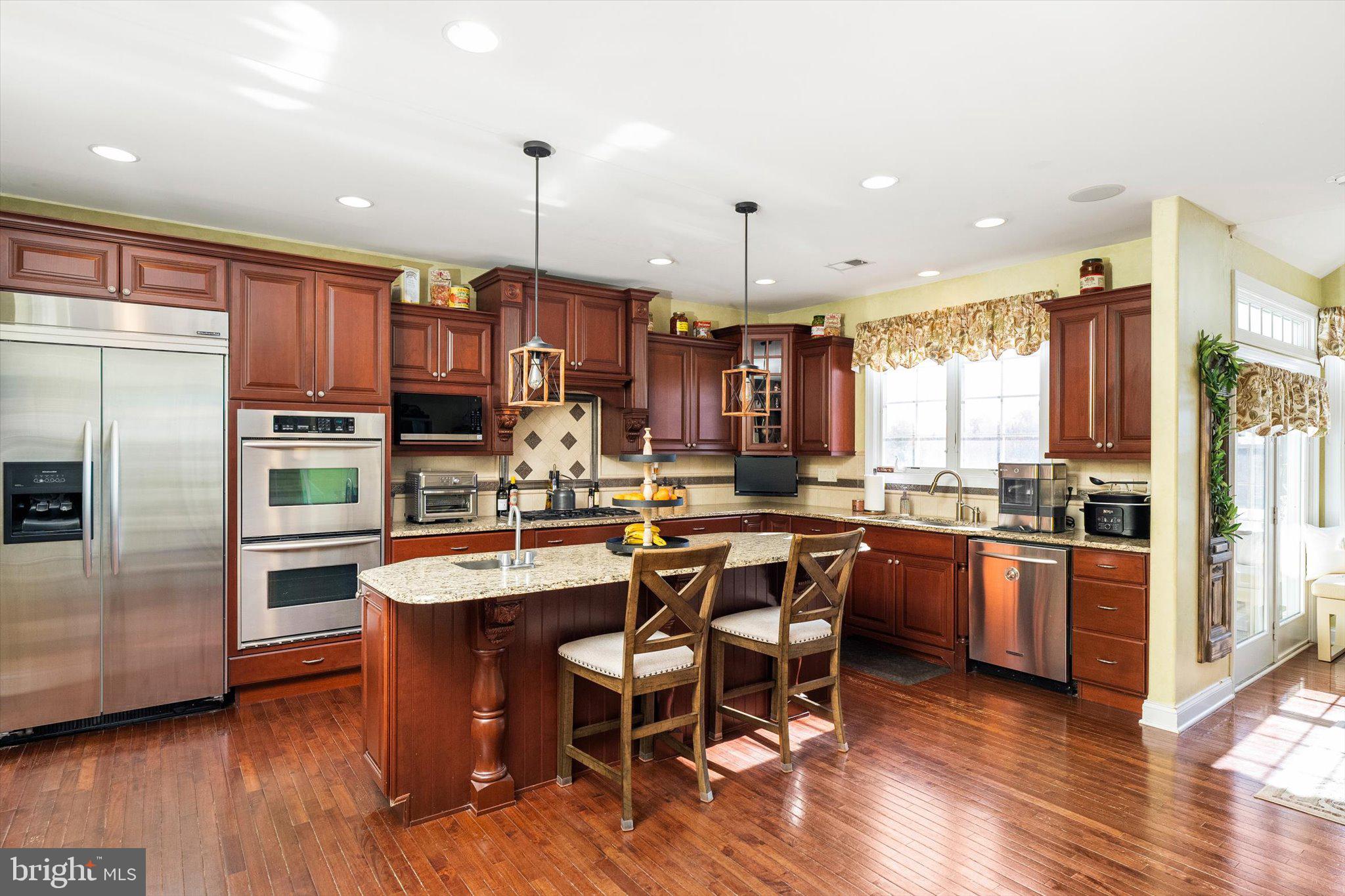 30 Ridgeview Way Allentown, NJ 08501 - Photo 22 of 57 a kitchen with stainless steel appliances granite countertop a stove top oven a refrigerator a sink and a dining table with wooden floor