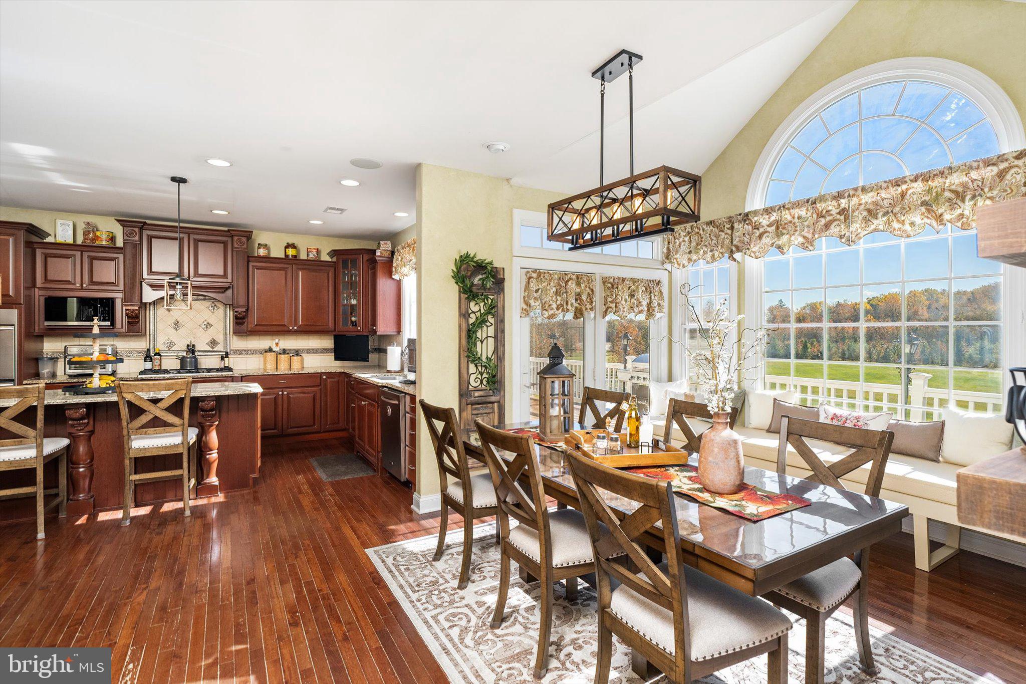 30 Ridgeview Way Allentown, NJ 08501 - Photo 24 of 57 a kitchen with stainless steel appliances kitchen island granite countertop a table chairs and a wooden floor