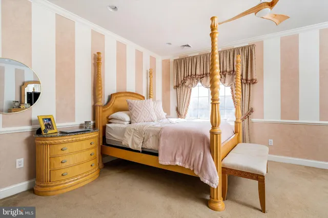 a spacious bedroom with a bed and a table lamp