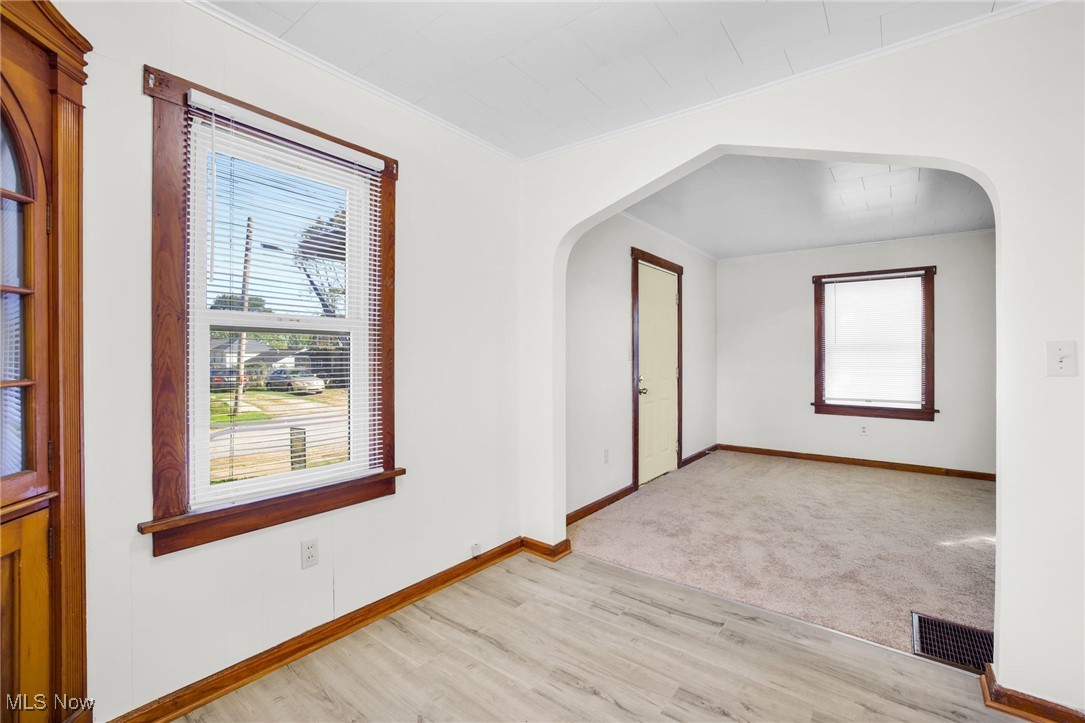 17 Ganyard Street Rittman, OH 44270 - Photo 4 of 16 Unfurnished room featuring arched walkways, light wood-type flooring, and ornamental molding