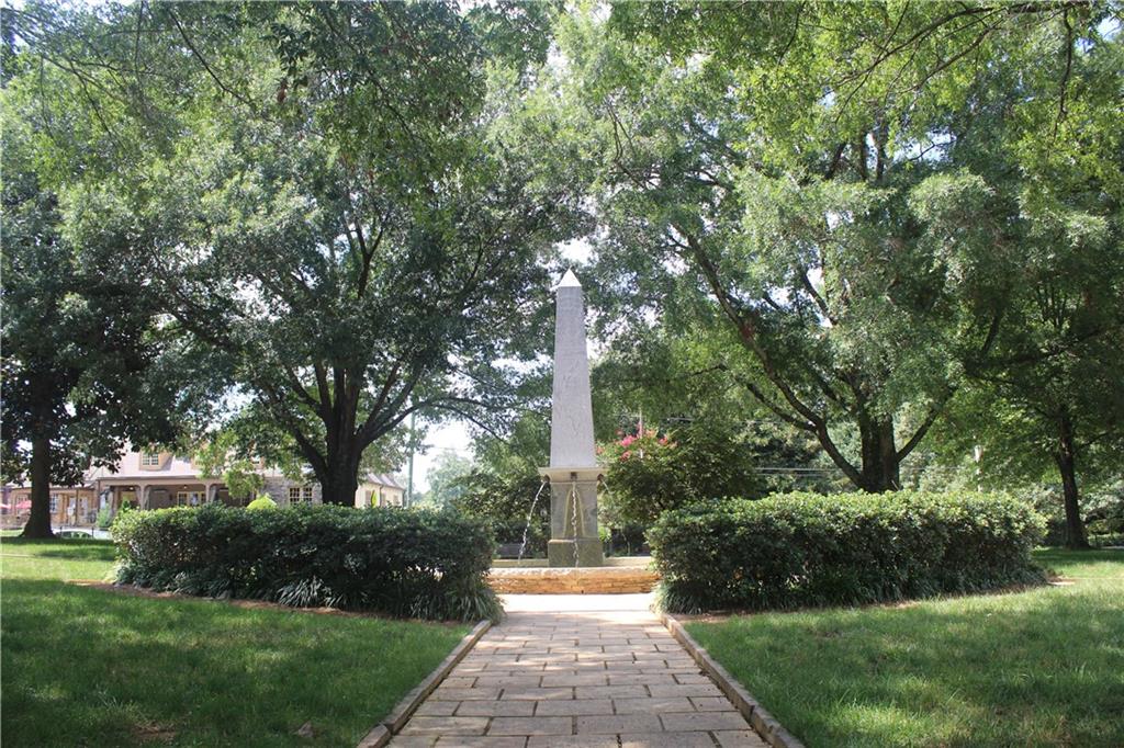 69 Maple Street Roswell, GA 30075 - Photo 17 of 22 a front view of a house with a yard and fountain in middle