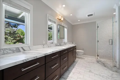 a bathroom with a sink mirror and a shower