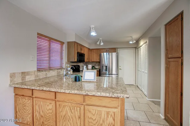 a kitchen with stainless steel appliances granite countertop a sink refrigerator and microwave