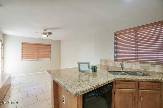 a kitchen with granite countertop a sink and a white cabinets