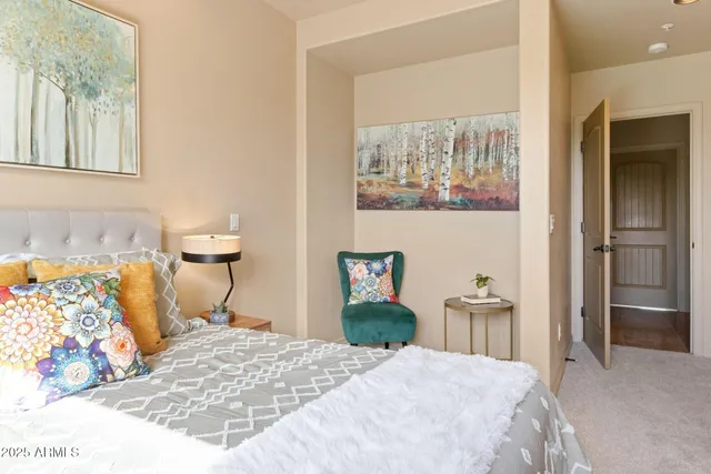 a bedroom with a bed table flowerpot and a potted plant