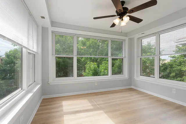 a view of an empty room with a window and a ceiling fan