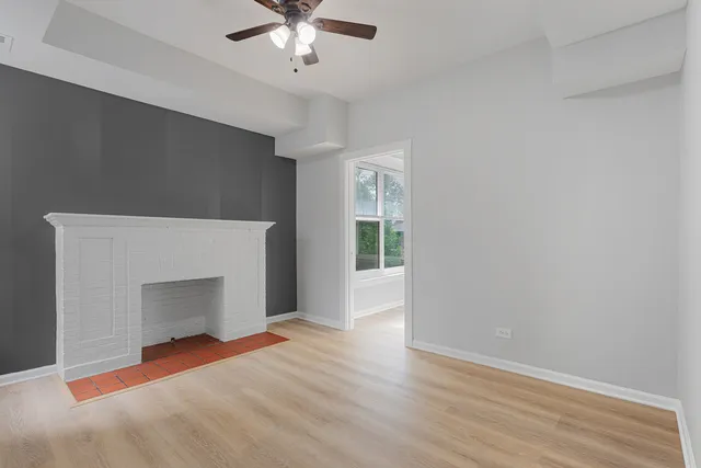 wooden floor fireplace and windows in an empty room