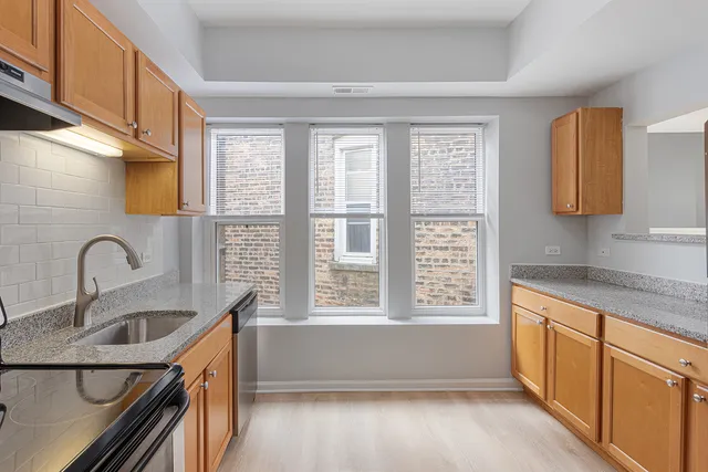 a kitchen with granite countertop a sink and a stove top oven