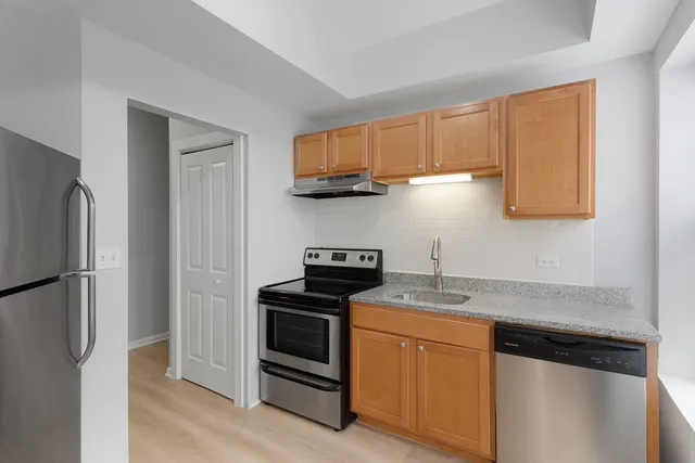 a kitchen with stainless steel appliances granite countertop a refrigerator sink and stove
