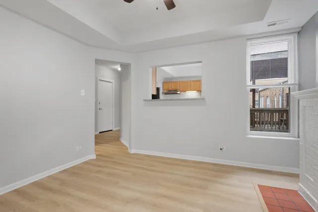 a view of an empty room with window and wooden floor