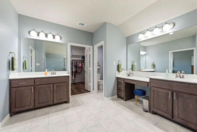 a spacious bathroom with a sink double vanity and a large mirror