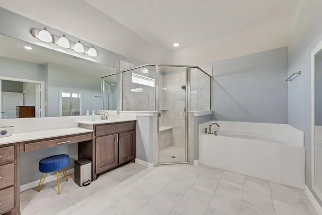 a bathroom with a granite countertop sink a toilet a mirror and bathtub