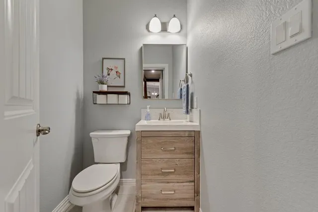 a bathroom with a toilet a sink and mirror