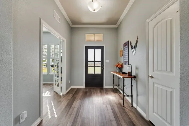 a view of a hallway with wooden floor and windows