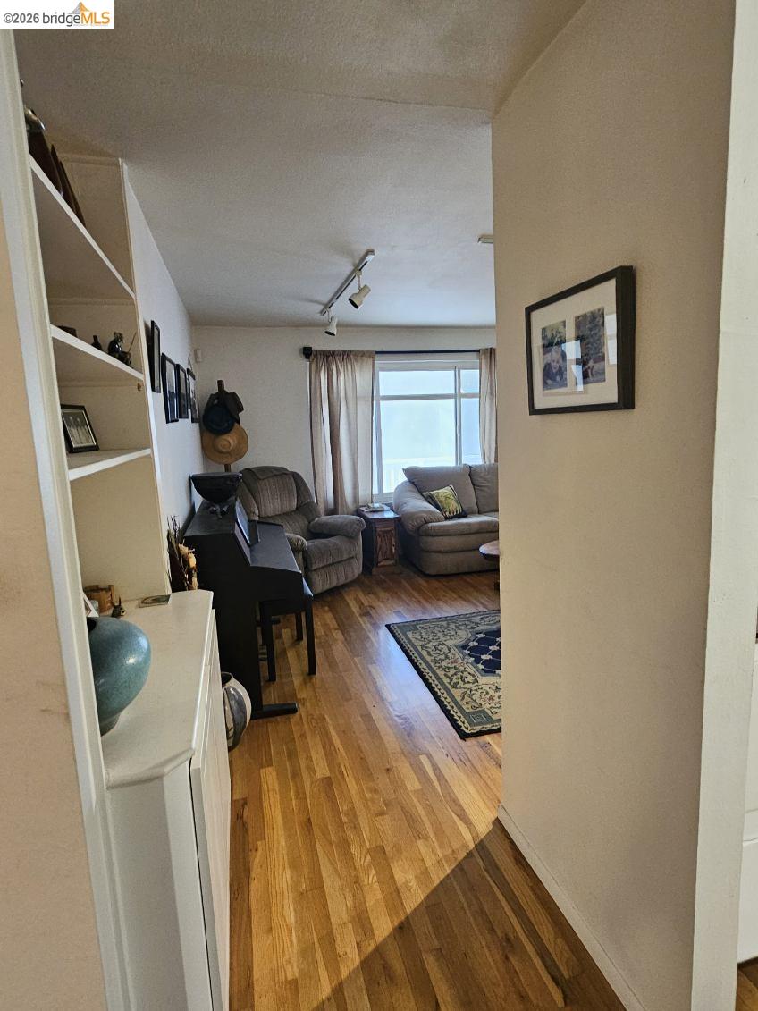 19967 Peaceful Oak Road Sonora, CA 95370 - Photo 11 of 35 Living room with light wood-type flooring, rail lighting, and a textured ceiling