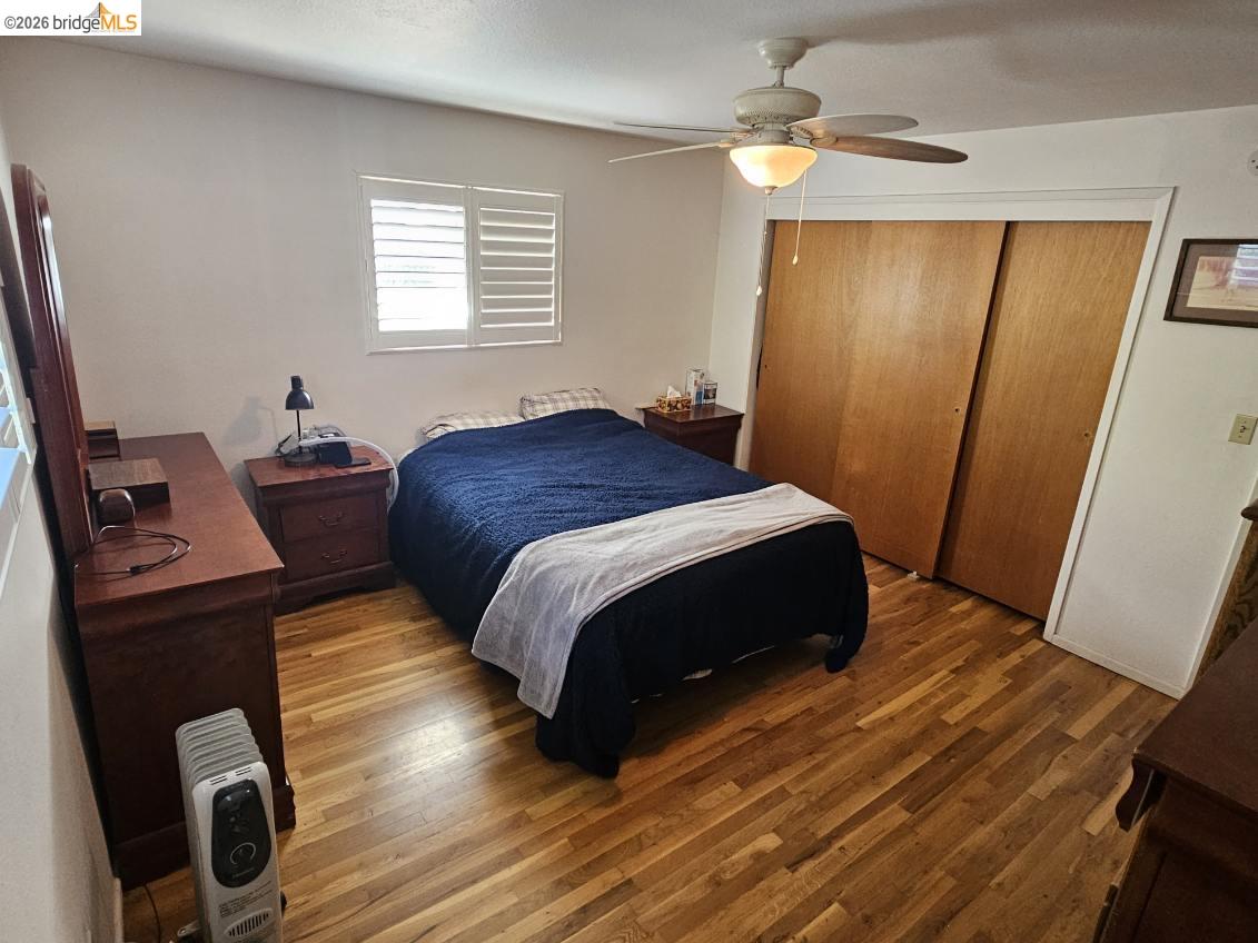 19967 Peaceful Oak Road Sonora, CA 95370 - Photo 13 of 35 Bedroom with wood finished floors, a closet, and ceiling fan