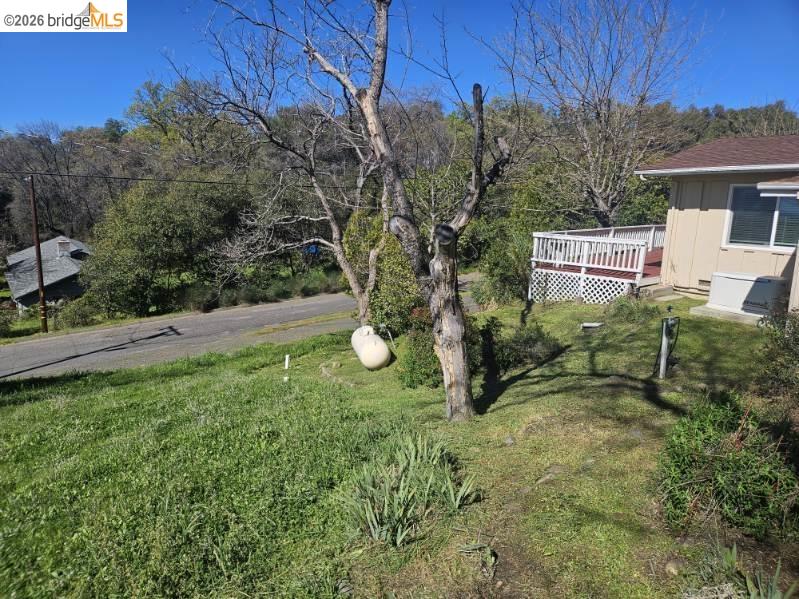 19967 Peaceful Oak Road Sonora, CA 95370 - Photo 29 of 35 View of grassy yard featuring a deck and view of scattered trees