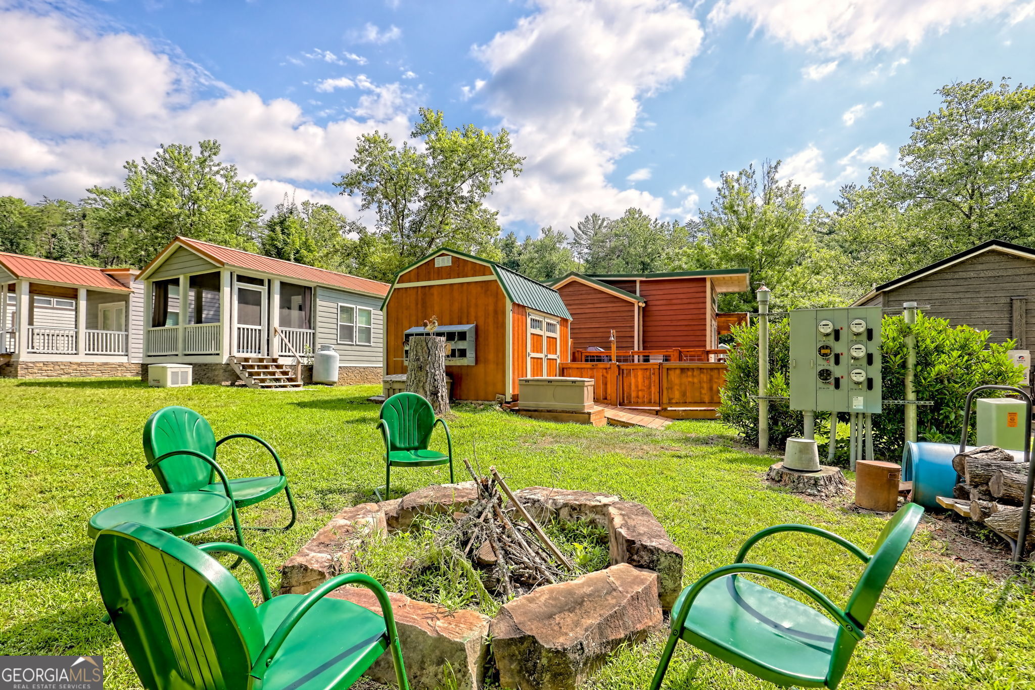 4960 Laurel Lodge Road, Unit 18 Clarkesville, GA 30523 - Photo 54 of 59 a view of a patio with couches chairs potted plants and a palm tree