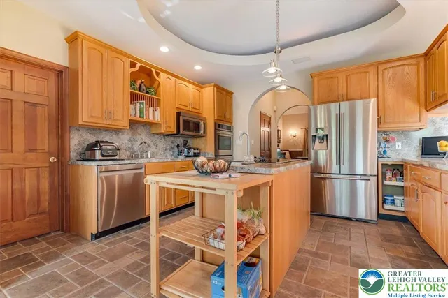 a kitchen with stainless steel appliances granite countertop a refrigerator and a sink