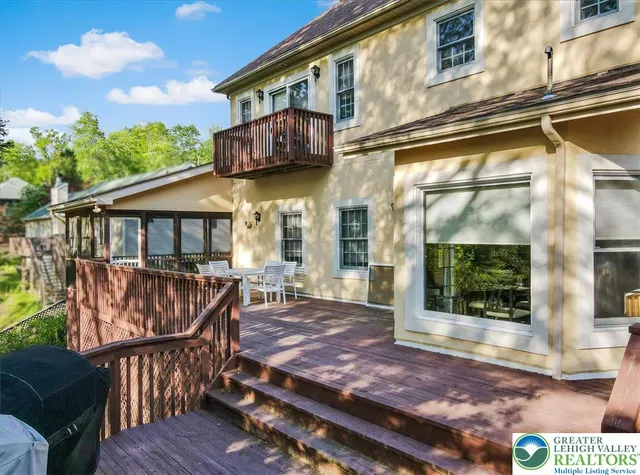 a view of a house with a wooden deck and furniture