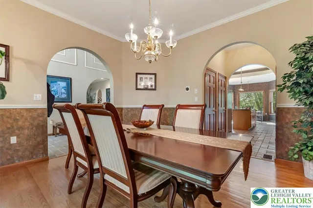 a view of a dining room with furniture a chandelier and wooden floor