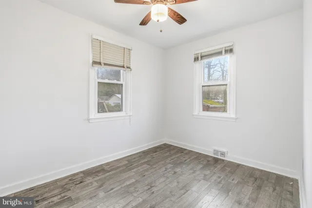 an empty room with a window and a ceiling fan