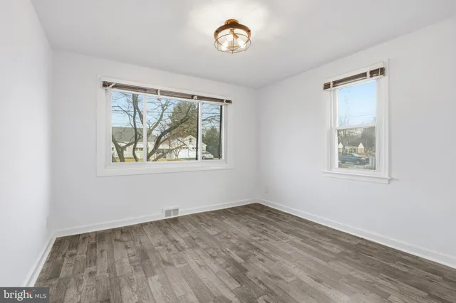 an empty room with a window and wooden floor
