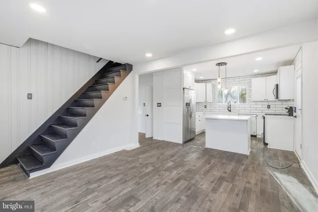 a view of kitchen with wooden floor and electronic appliances