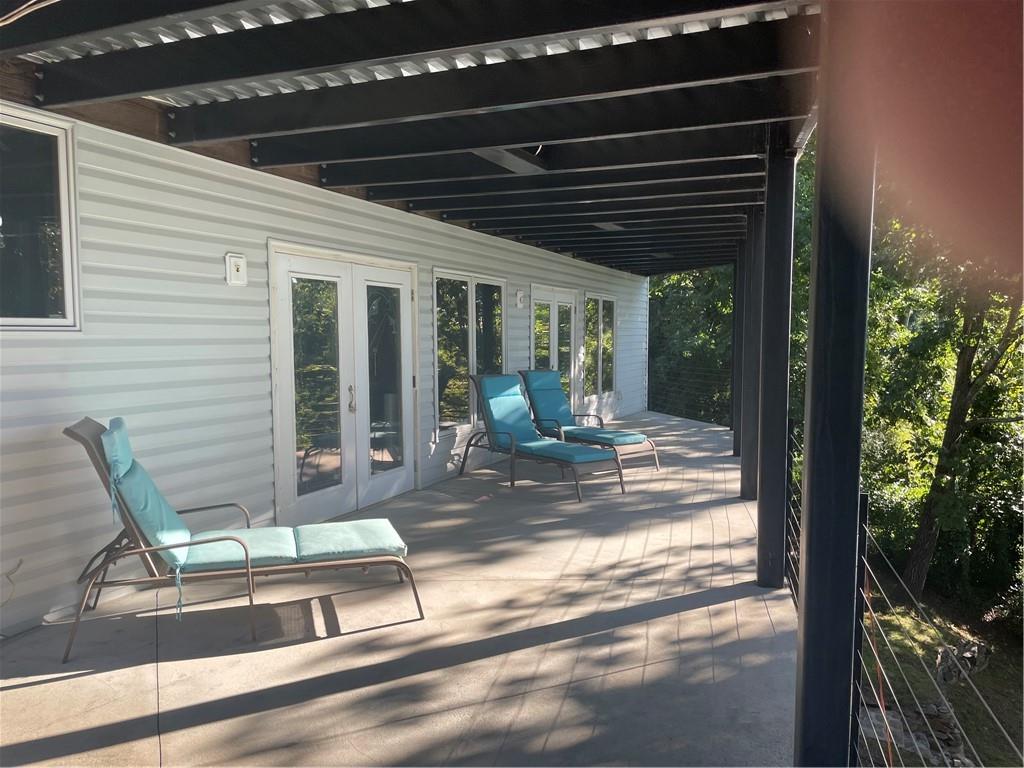 4265 Sinclair Shores Road Cumming, GA 30041 - Photo 15 of 18 a view of a porch with a table and chairs