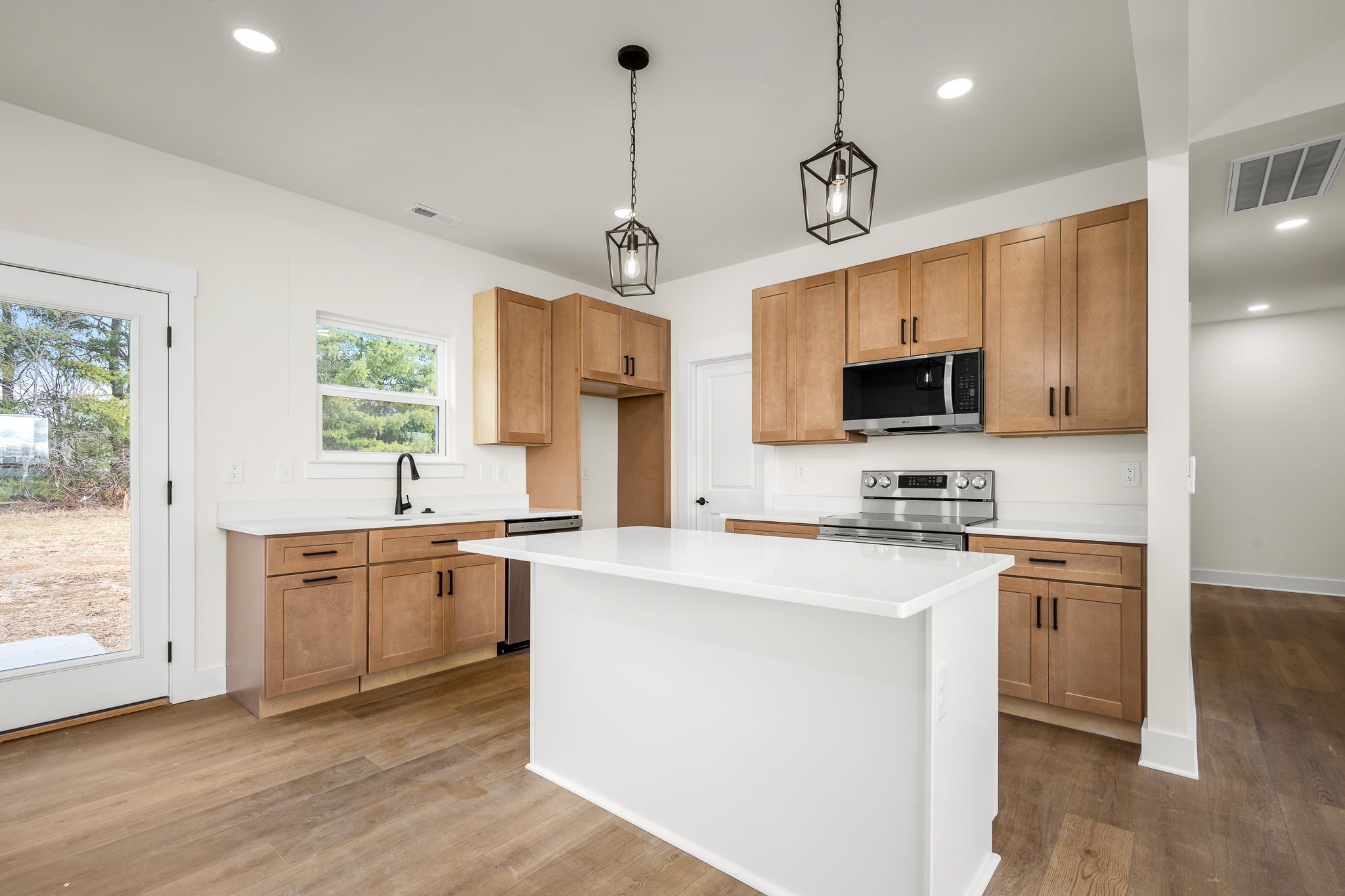 4151 Asbury Road Manchester, TN 37355 - Photo 12 of 32 a kitchen with stainless steel appliances kitchen island granite countertop a stove a sink and a microwave