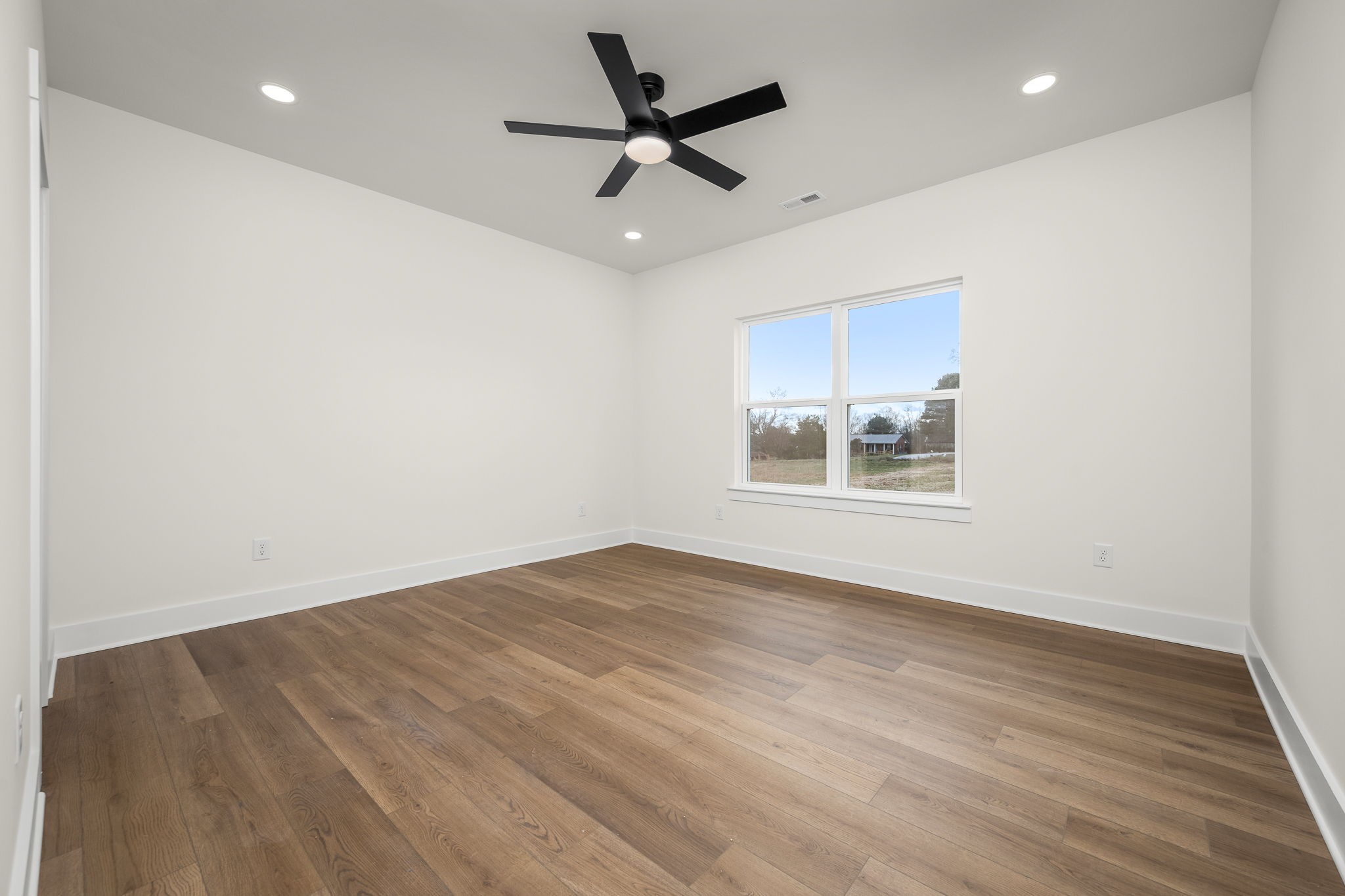 4151 Asbury Road Manchester, TN 37355 - Photo 17 of 32 an empty room with wooden floor ceiling fan and windows