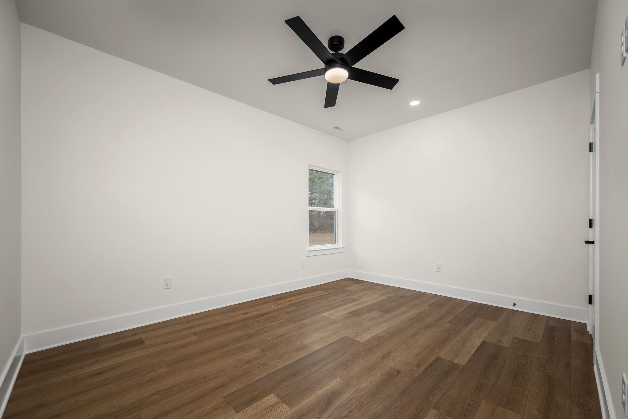 4151 Asbury Road Manchester, TN 37355 - Photo 24 of 32 an empty room with wooden floor and ceiling fan