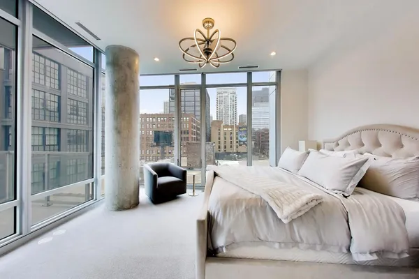 a bedroom with a bed and a large window