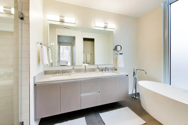 a bathroom with a double vanity sink mirror and bathtub