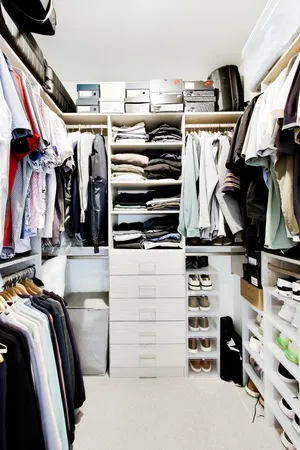 a view of walk in closet with clothes and shoes