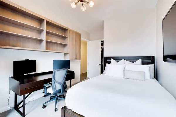 a bedroom with a bed and a desk