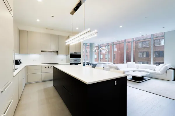 a kitchen with kitchen island a sink and white cabinets