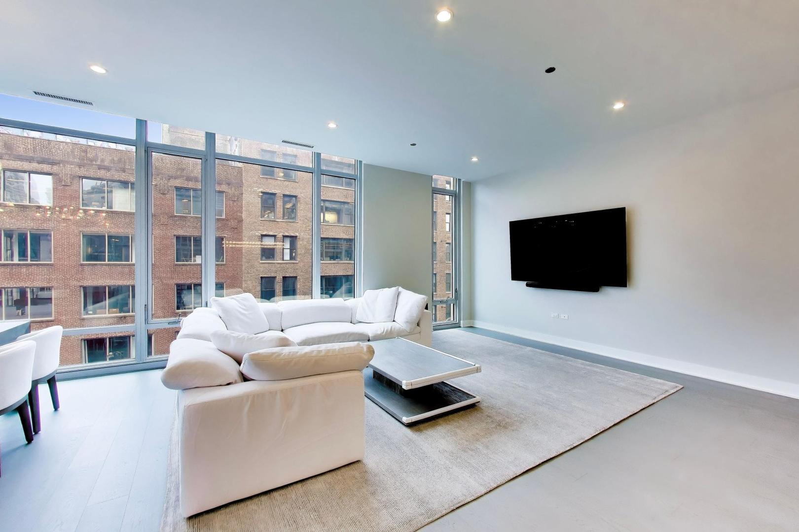 360 West Erie Street, Unit 5D Chicago, IL 60654 - Photo 5 of 41 a living room with furniture and a flat screen tv